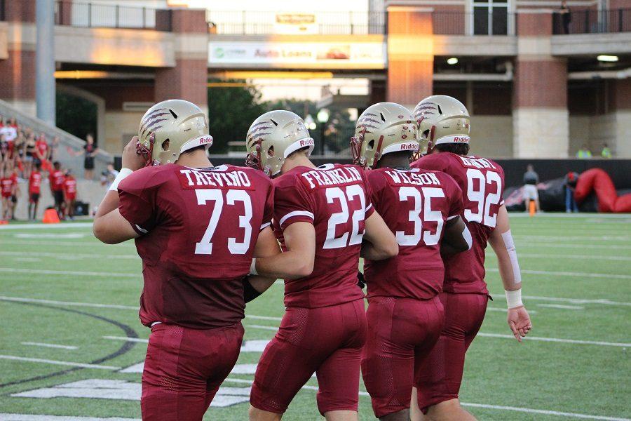 Team captains walking towards the center of the field before the coin toss.