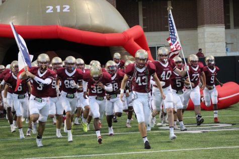 Wildcat Football team running on to the field. 