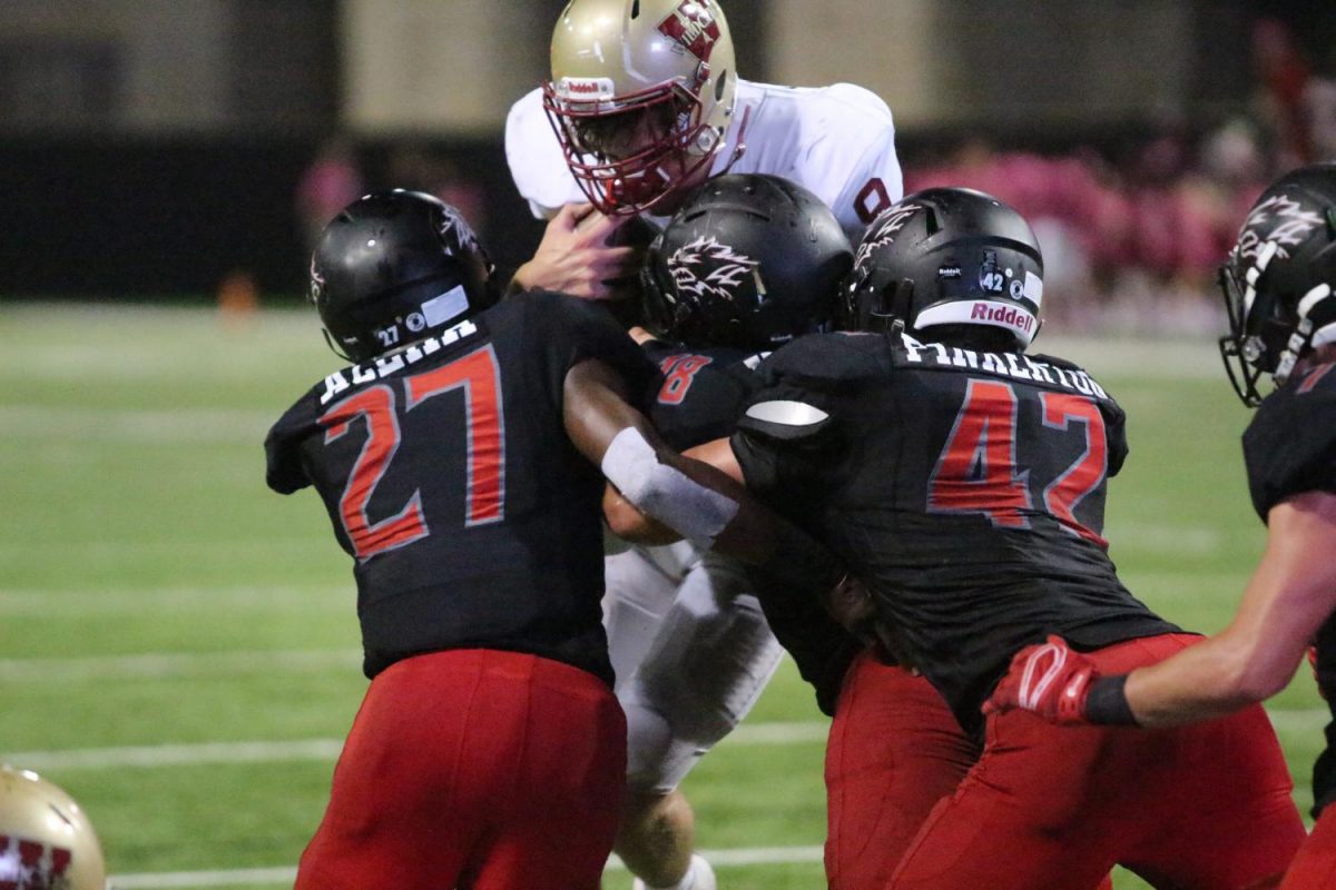 Quarterback Jackson Jones is tackled by multiple Langham Creek defenders as he attempts to make a two-point conversion during the fourth quarter.