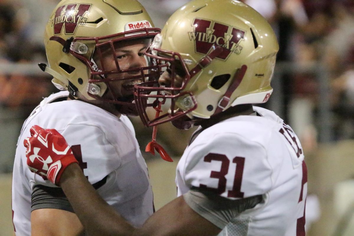 Defensive back Collin Fewox and wide receiver Derrick Brooks celebrate after recovering an onside kick.