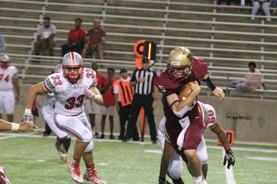 Quarterback Jackson Jones dodges a Cy Lakes defender as he runs with the ball during the second quarter.