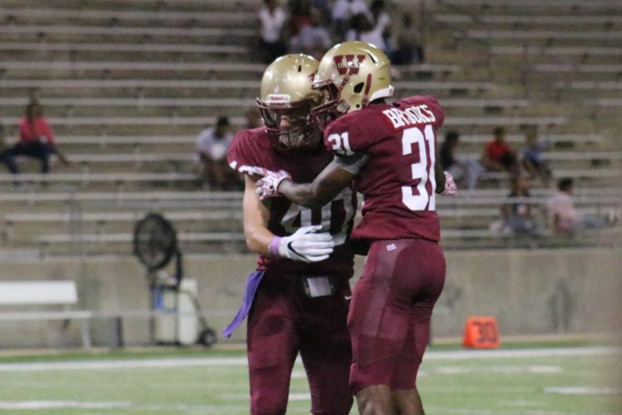 Defensive lineman Clancy Hall celebrates with defensive back Derrick Brooks after a quarterback sack in the third quarter.