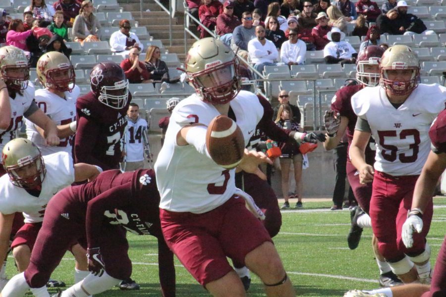 Quarterback Jacob Kainer passes the ball as he is about to be tackled during the fourth quarter.