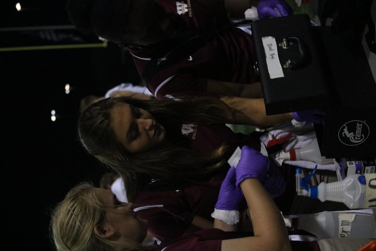 A group of athletic trainers organize their supplies during the third quarter.