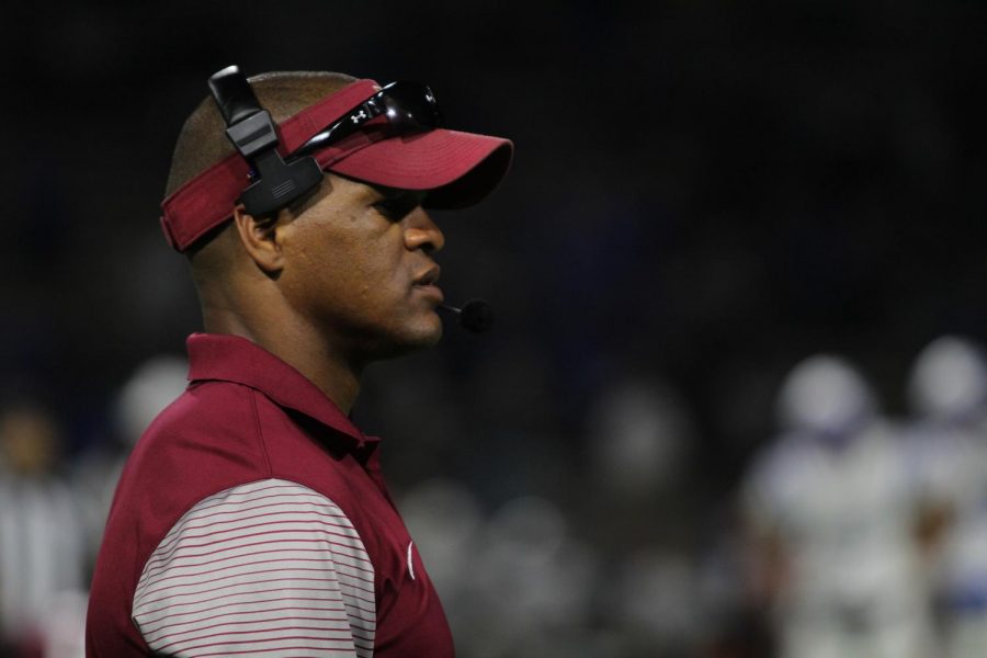 Football coach Andre Crumedy intently watches the game during the fourth quarter.