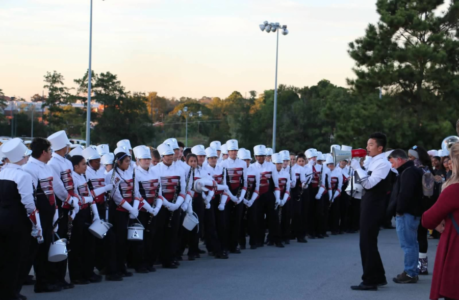 Drum major, Adrian Chan, speaks to the band before a performance