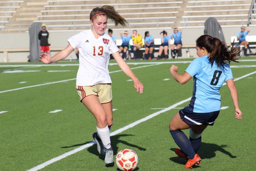 Sophomore Taylor Sims tries to keep control of the ball from a Lamar player during the game against Lamar High School.