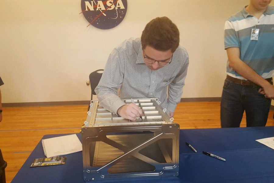 James Keiser signing a locker made by HUNCH students.