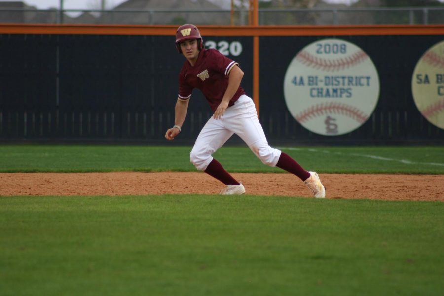 Varsity baseball player and choir student, senior Jackson Sutter runs between bases during a game.