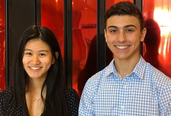 Eileen Lee and Sam Torres pose for a picture in-front of the National Merit wall