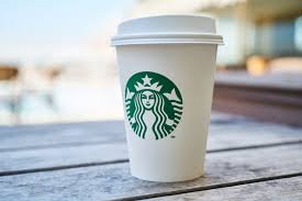 A Starbucks coffee cup on top of a table.