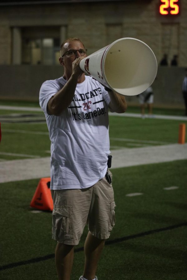 Associate Principal Dirk Heath rallies the crowd with the use of a megaphone at varsity football game against Cy-Ridge on September 27