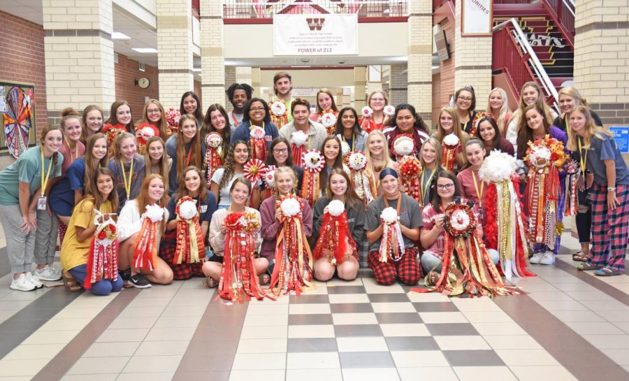 Wildcat students stand with their donated mums and garters before handing them to their life skills buddy.