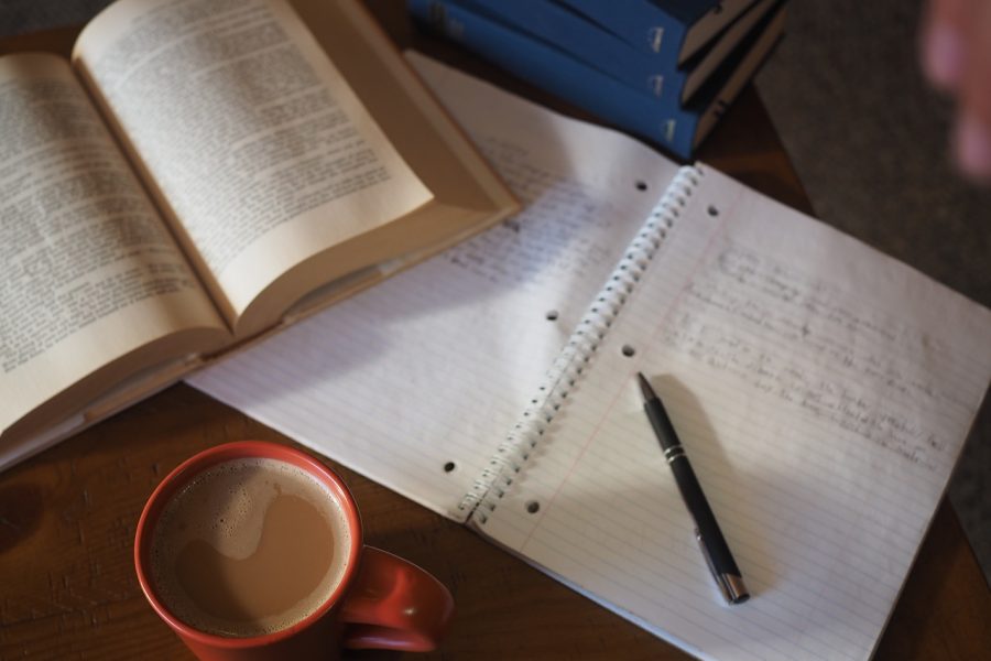 Coffee and books being used to make studying comfortable.