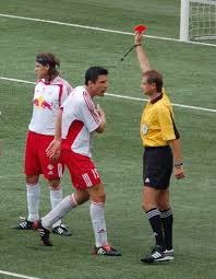 Thomas Linke of Red Bull Salzburg is shown a red card after committing a foul.