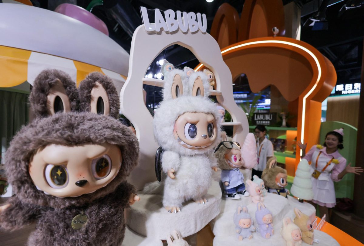 An employee gestures next to Labubu toys on display at Pop Mart’s booth at China International Fair for Trade in Services (CIFTIS) in Beijing, China, September 10, 2025. REUTERS/Maxim Shemetov