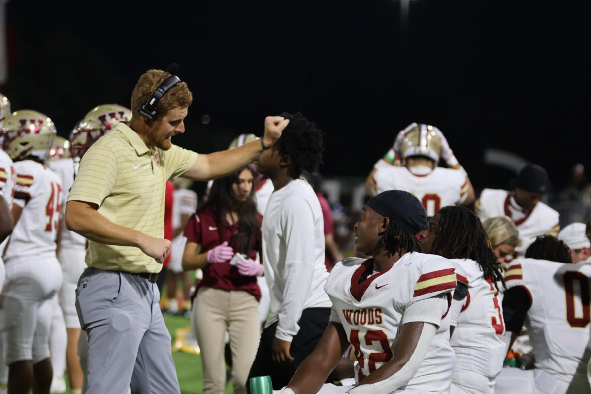 Coach Chase Brown works with senior Jaiden Ogletree on the sidelines during the Cy Creek game.